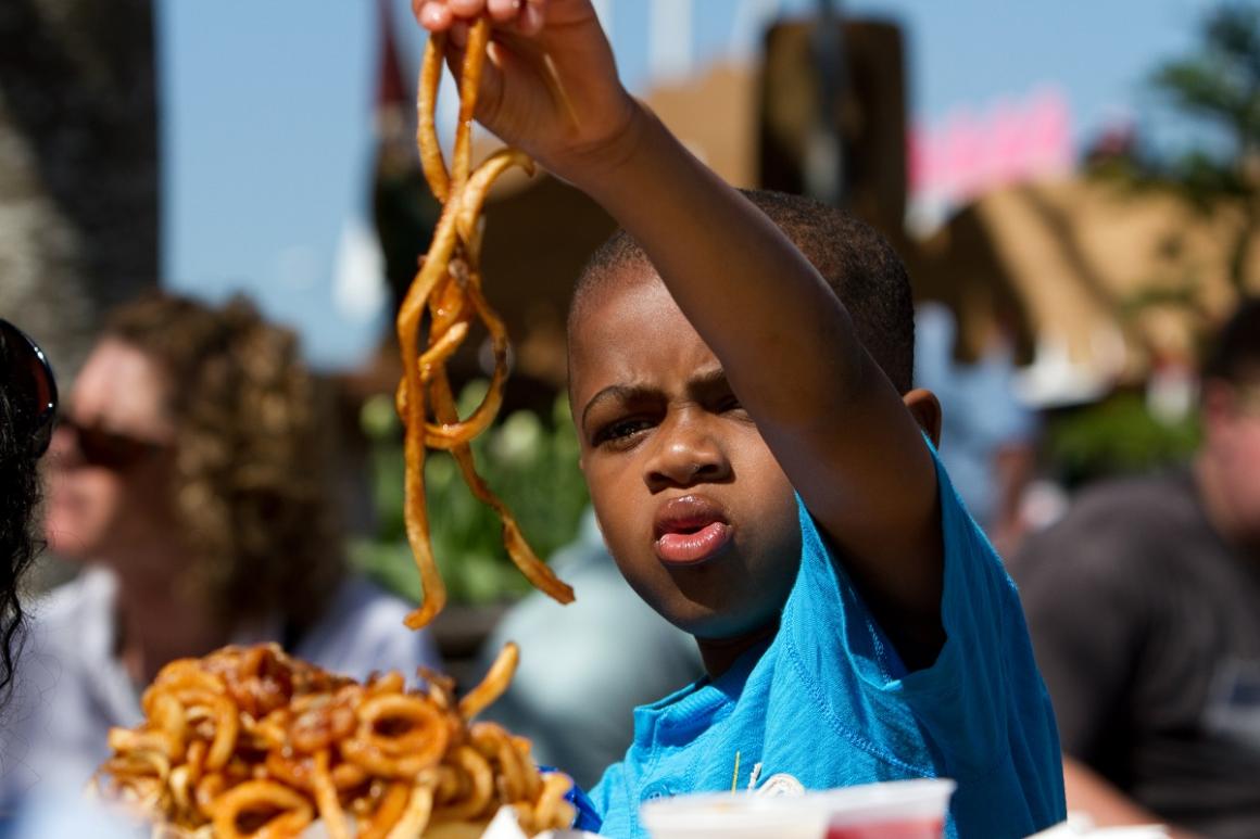 Boy eating large order of curly fries at the Washington State Fair in Puyallup